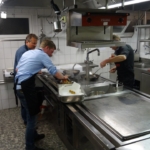 Drei Männer arbeiten in einer Küche im Hotel
